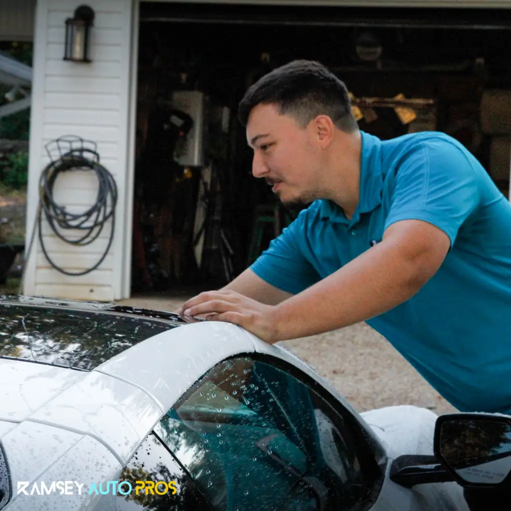 Carson the owner of Ramsey Auto Pros applying Paint Protection Film onto a White Car