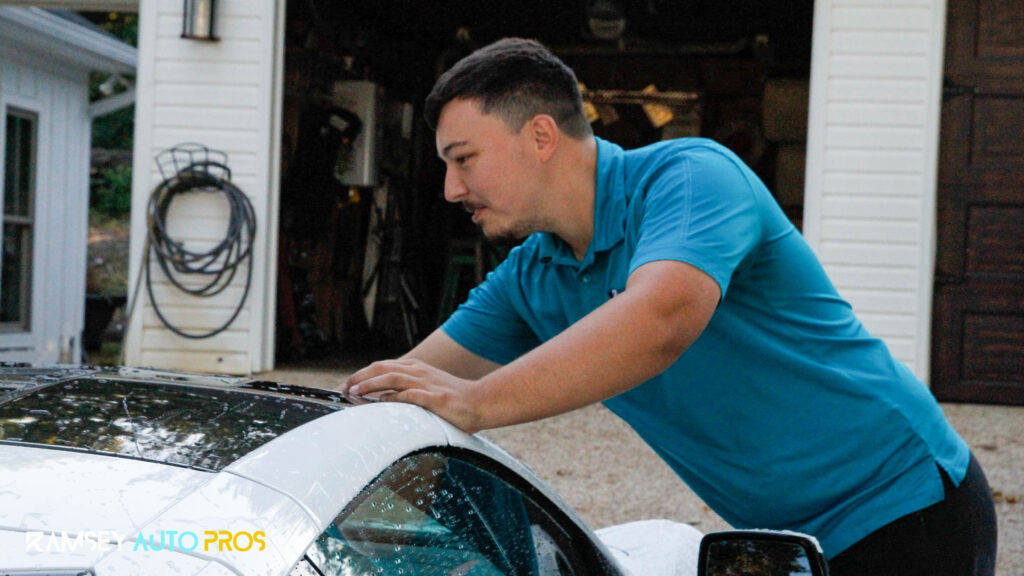 Carson the owner of Ramsey Auto Pros applying Paint Protection Film onto a White Car